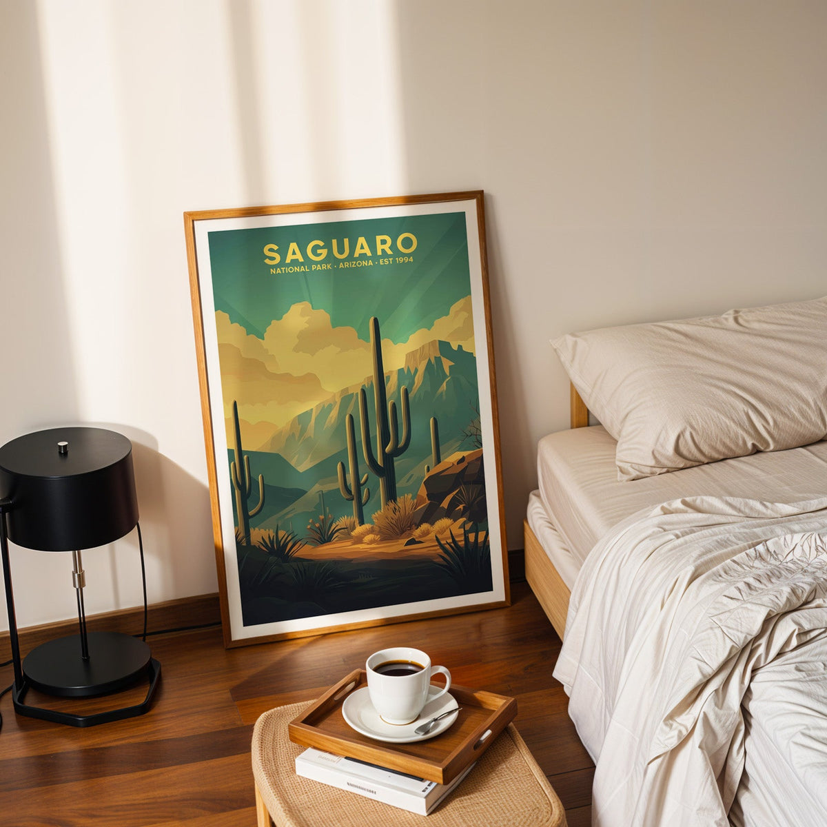 Saguaro National Park print in an oak frame leaning on a bedroom floor beside the bed and a coffee tray