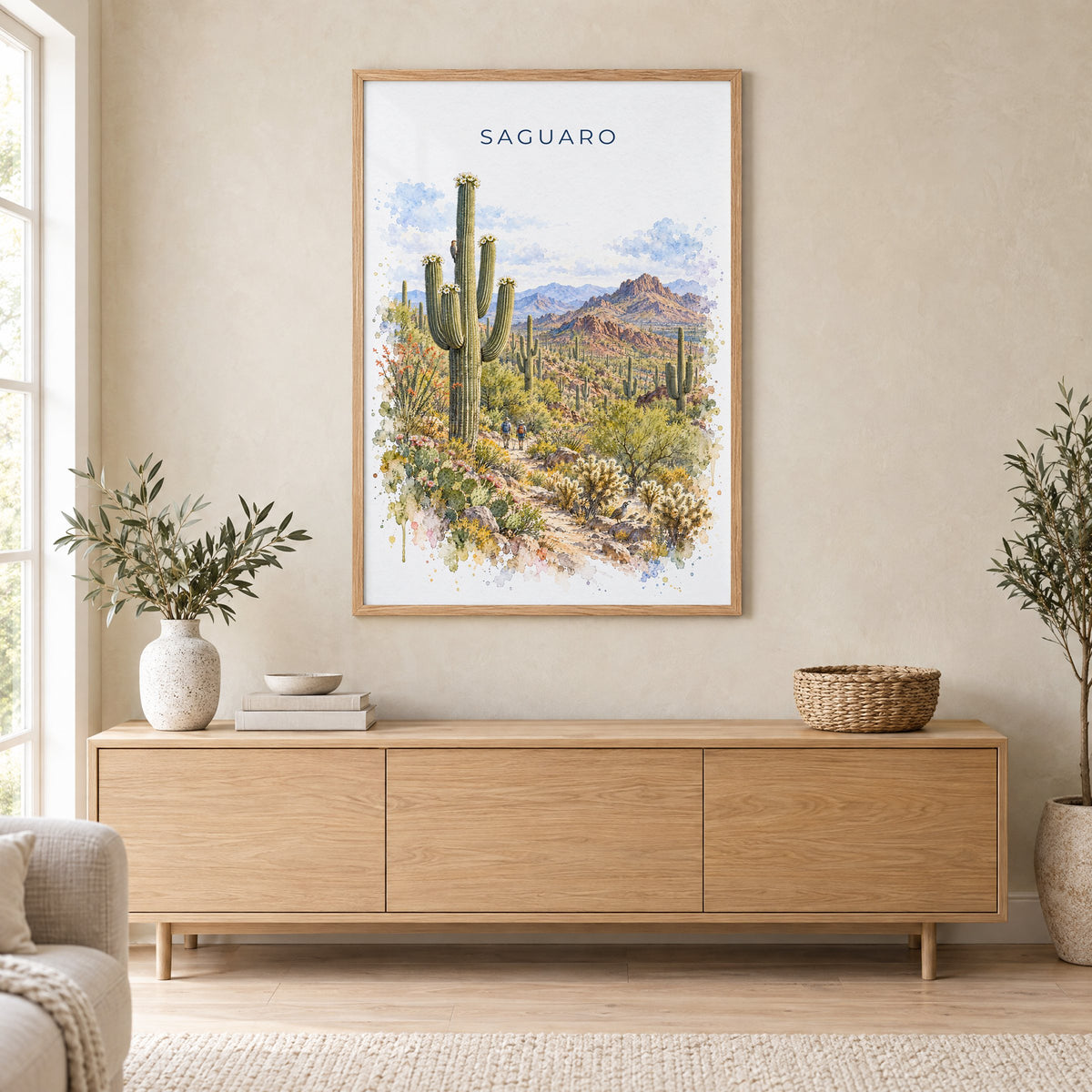 Saguaro National Park watercolor print in an oak frame above a light wood sideboard in a Scandinavian living room