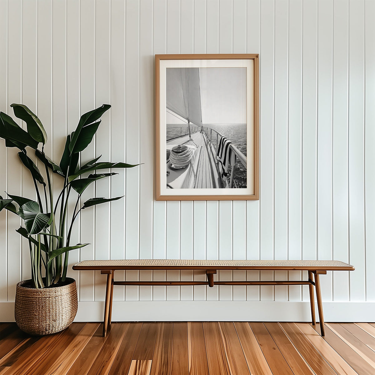 Sailboat deck with rope coil and striped towel print in a wood frame with a white mat above a cane bench