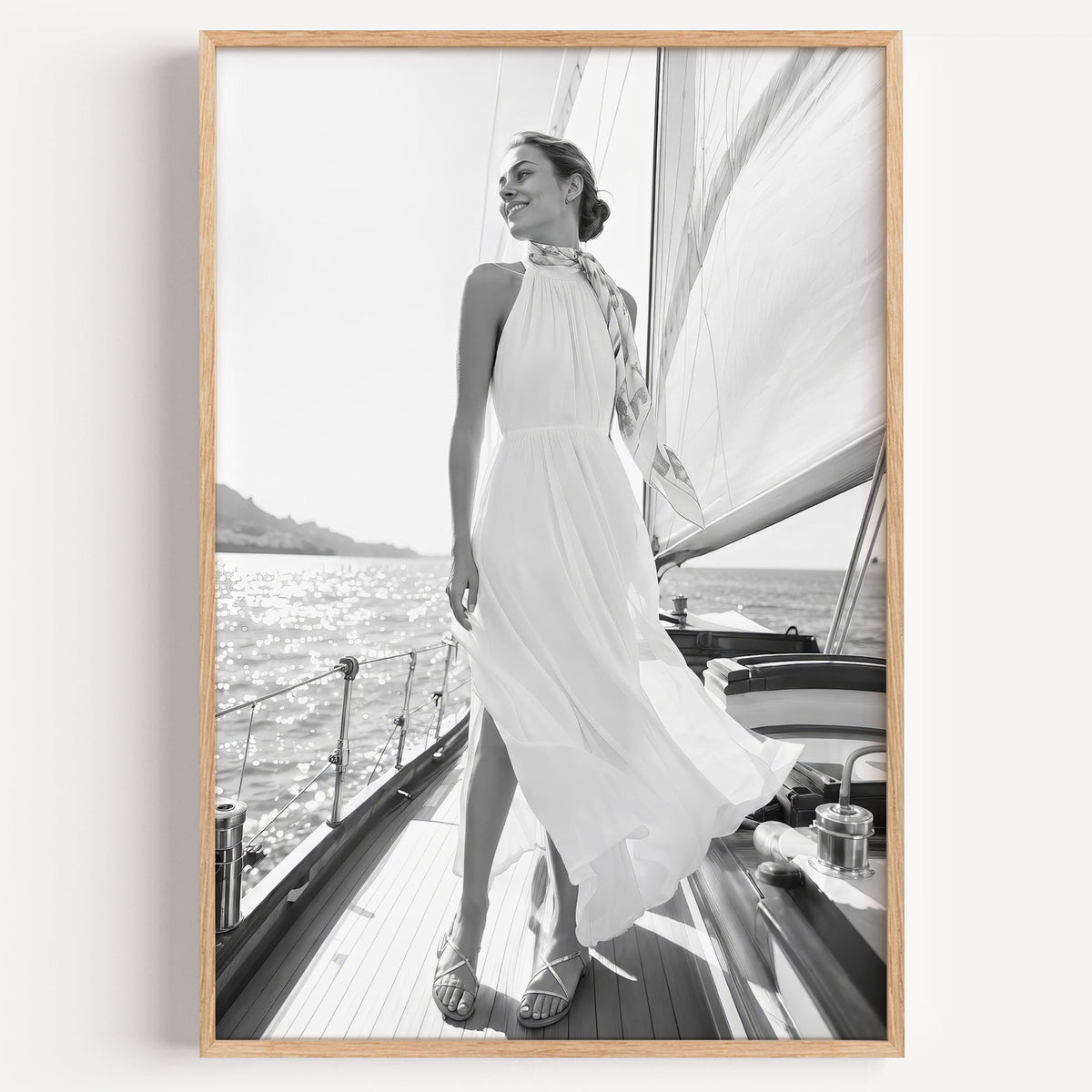 Black and white woman in white dress on sailboat print in a light oak frame on a plain white wall