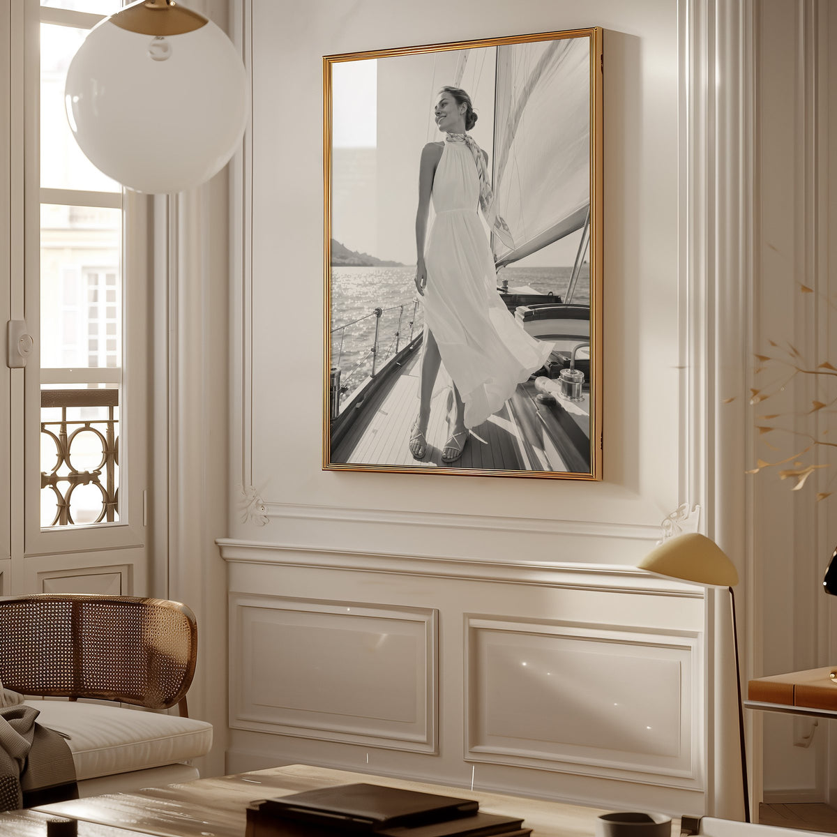 Black and white woman in white dress on sailboat print shown in a gold frame in a Parisian paneled living room