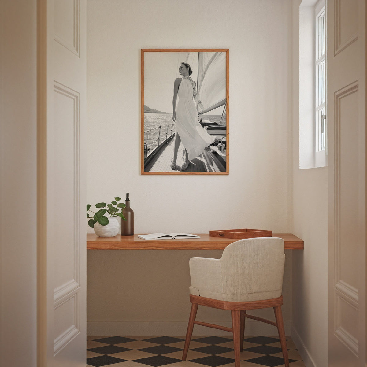 Black and white woman in white dress on sailboat print in an oak frame above a home office desk nook