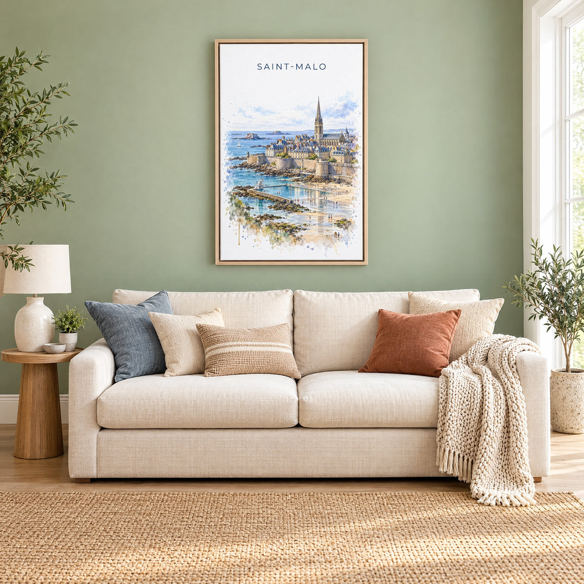 Saint-Malo watercolor print as a natural floater canvas above a cream linen sofa on a sage green wall