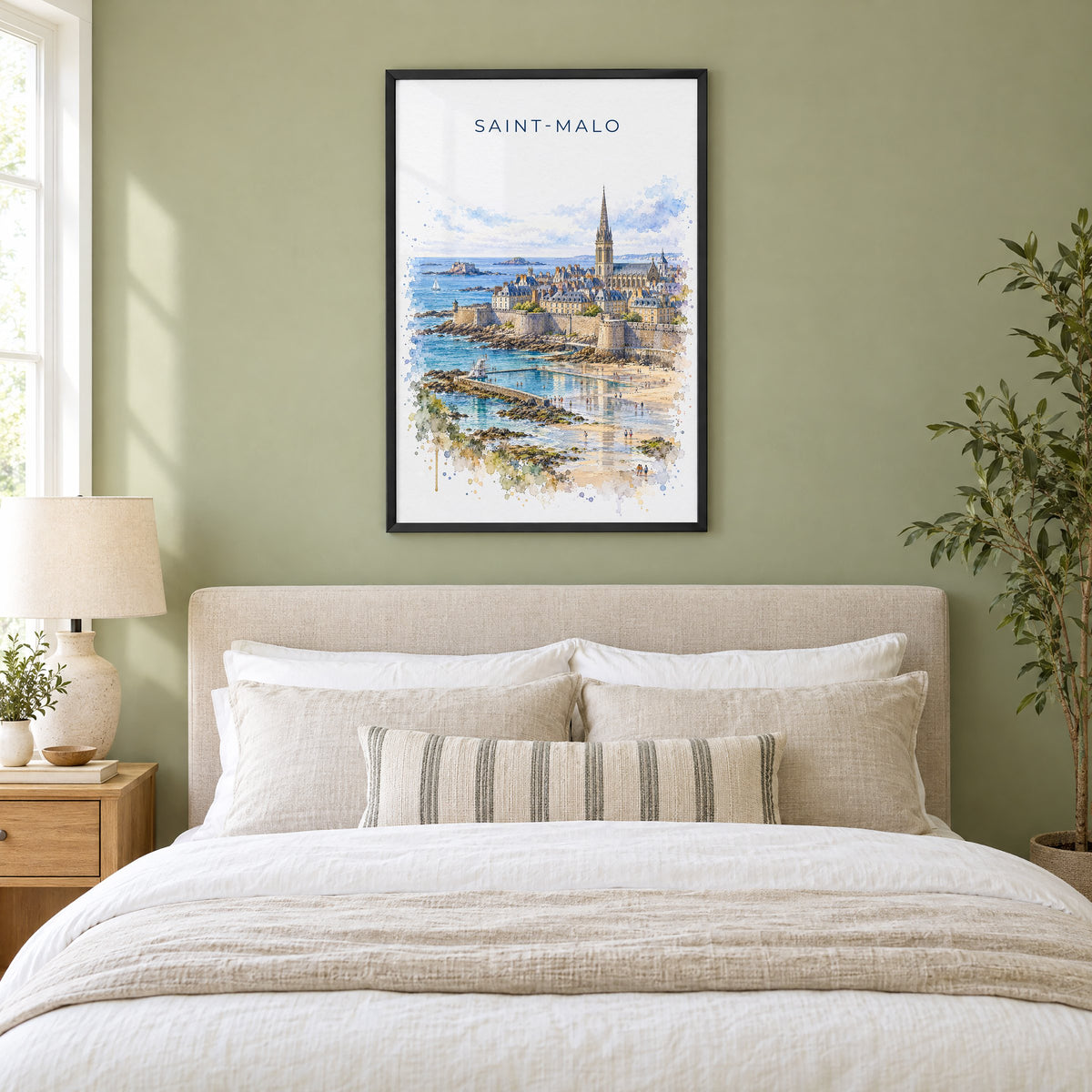 Saint-Malo watercolor print in a black frame above an upholstered headboard in a sage green bedroom