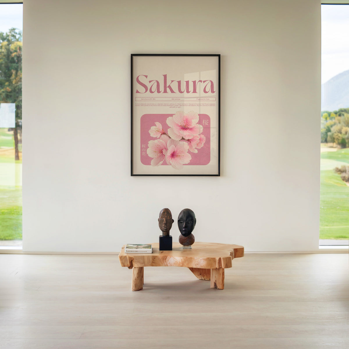 pink sakura blossom typography print in a black frame above a live-edge wood coffee table between garden windows
