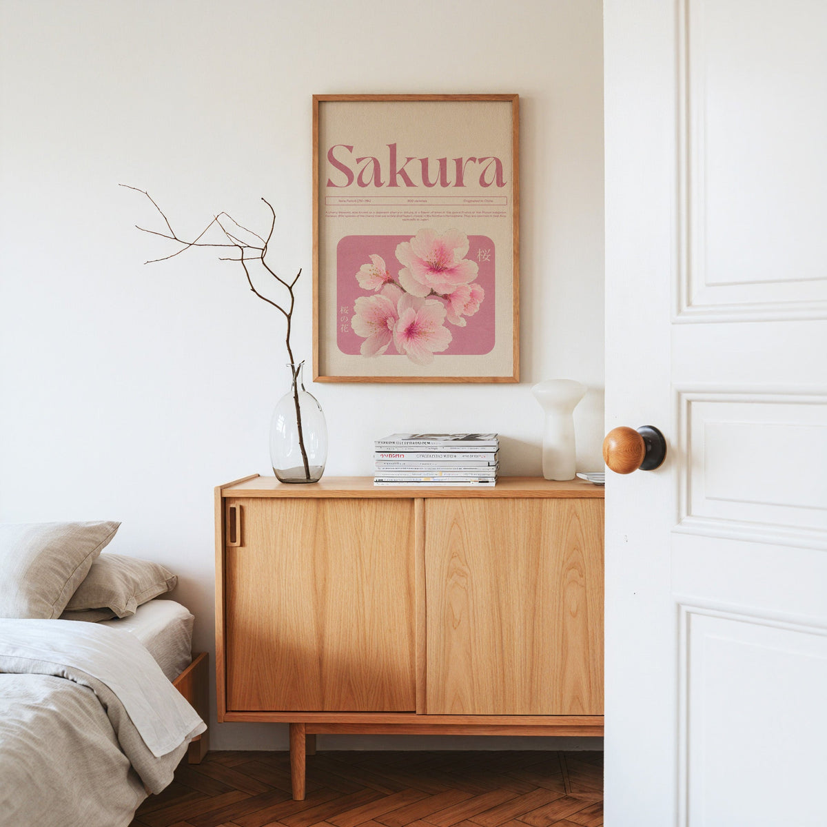 pink sakura blossom typography print in an oak frame above an oak sideboard in a bedroom with linen bedding