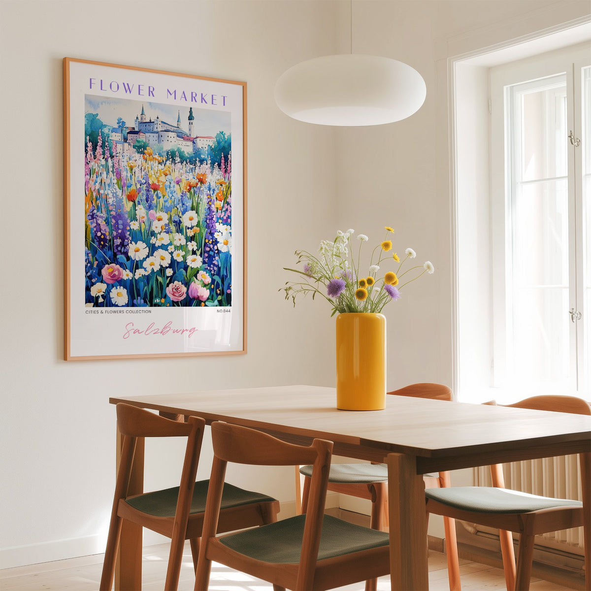 Salzburg flower market print in an oak frame above a dining table with a yellow vase and white pendant light