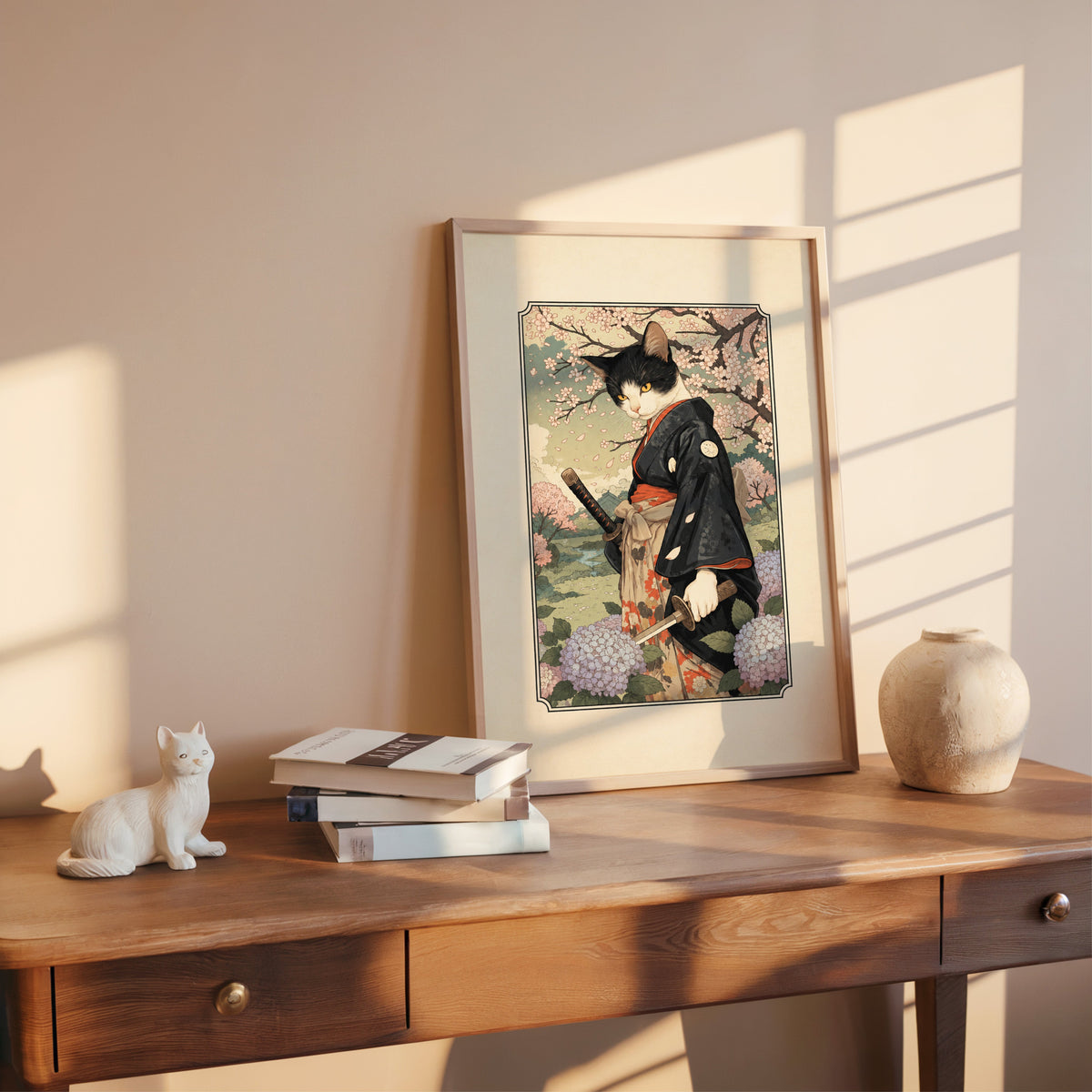 samurai cat with katana print shown in a rose gold frame leaning on a wooden writing desk with books