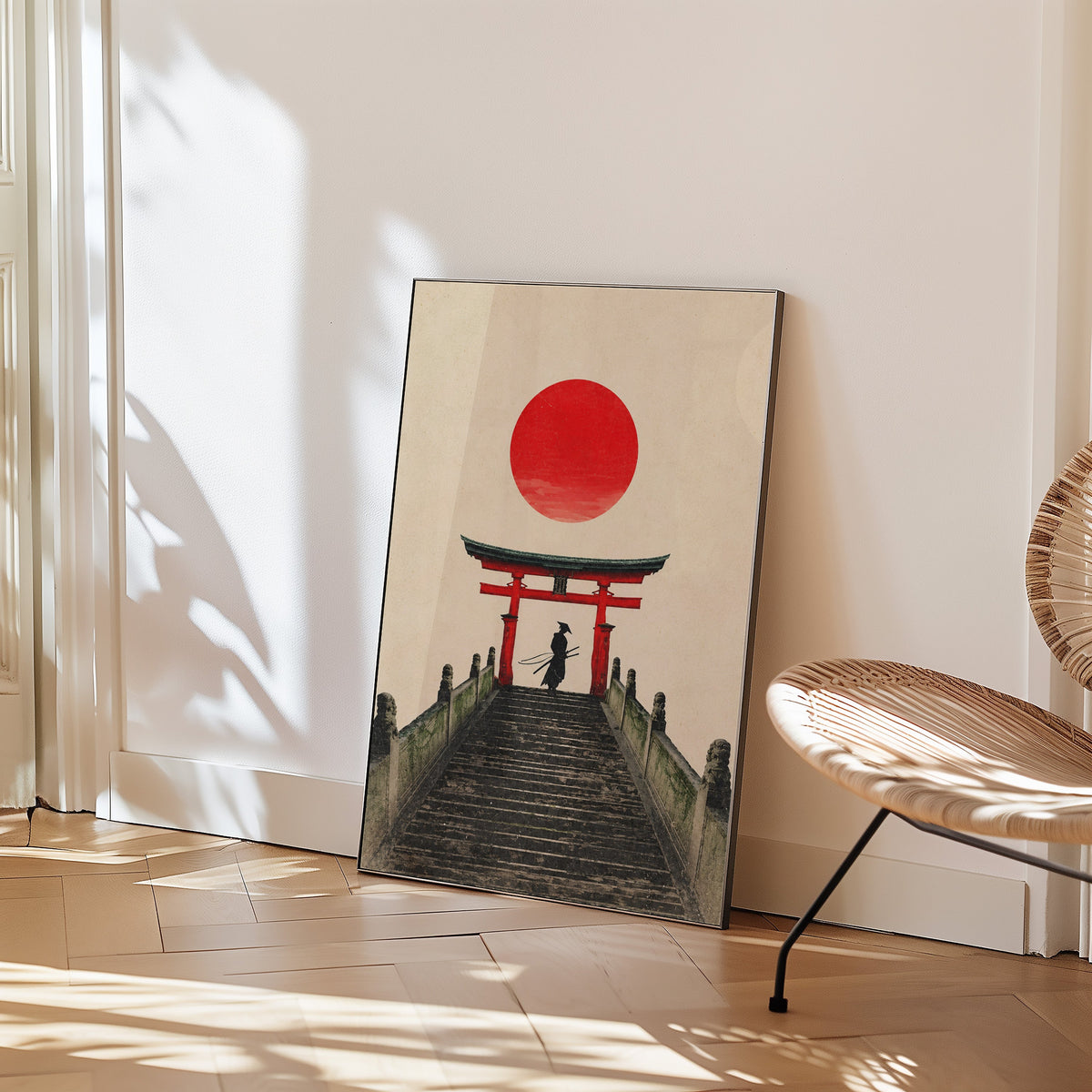 samurai under red torii gate print in a black frame leaning on a herringbone floor beside a woven rattan chair