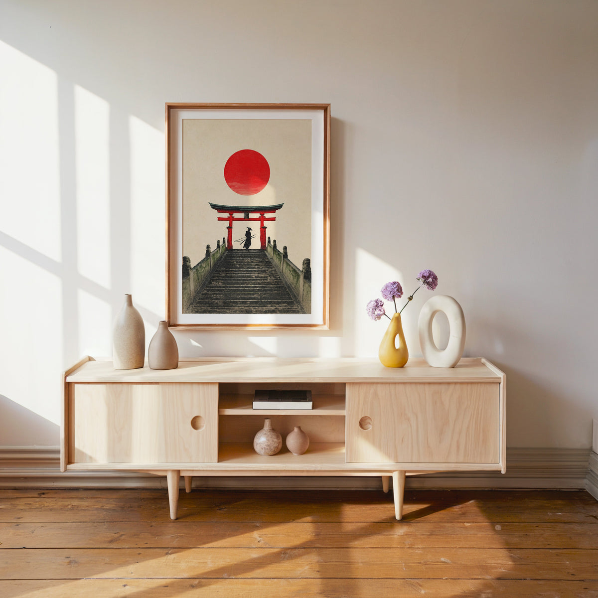 samurai under red torii gate print shown in a wood frame with a white mat above a pale wood media console