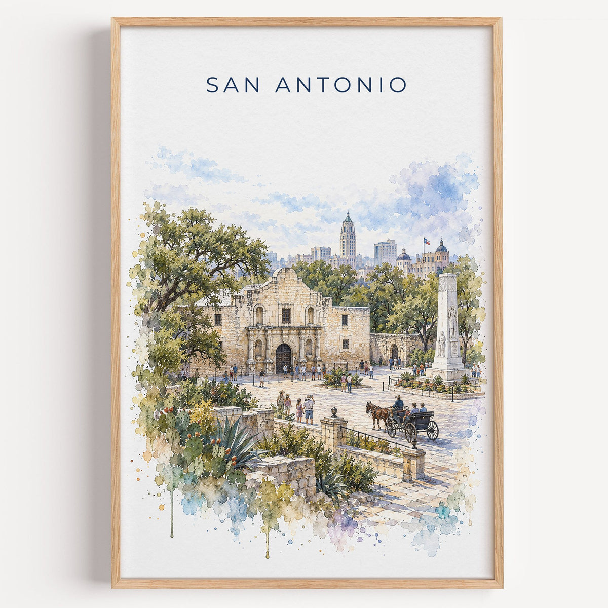 San Antonio watercolor print in a light oak frame on a plain white wall