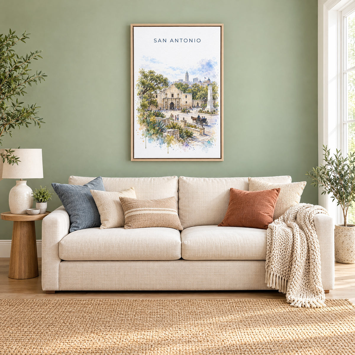 San Antonio watercolor print as a natural floater canvas above a cream linen sofa on a sage green wall