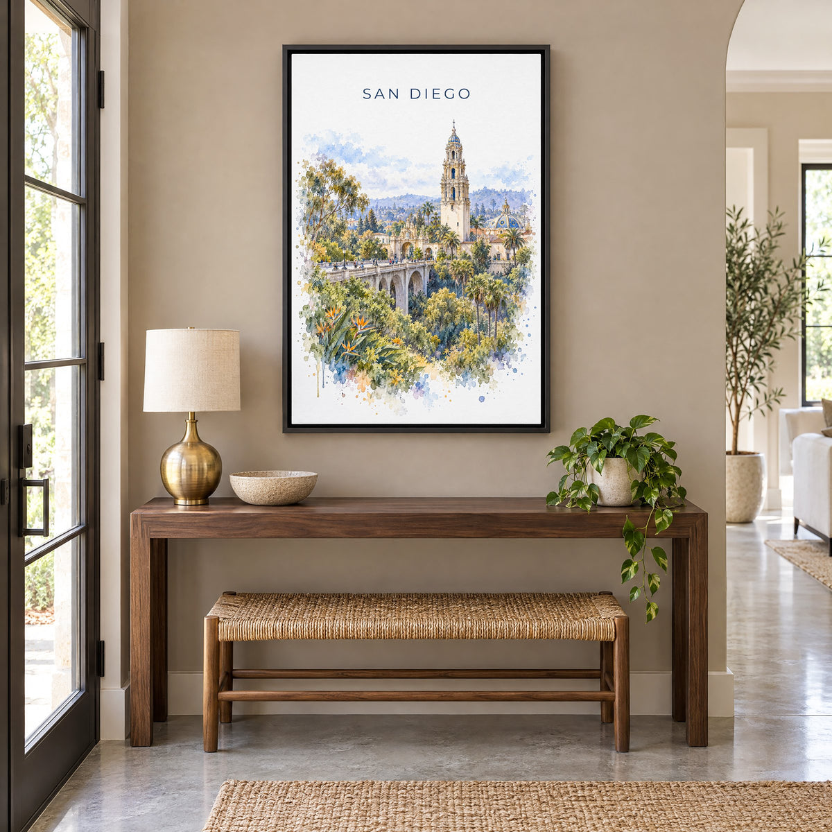 San Diego watercolor print as a black floater canvas above a walnut console and woven bench in an entryway
