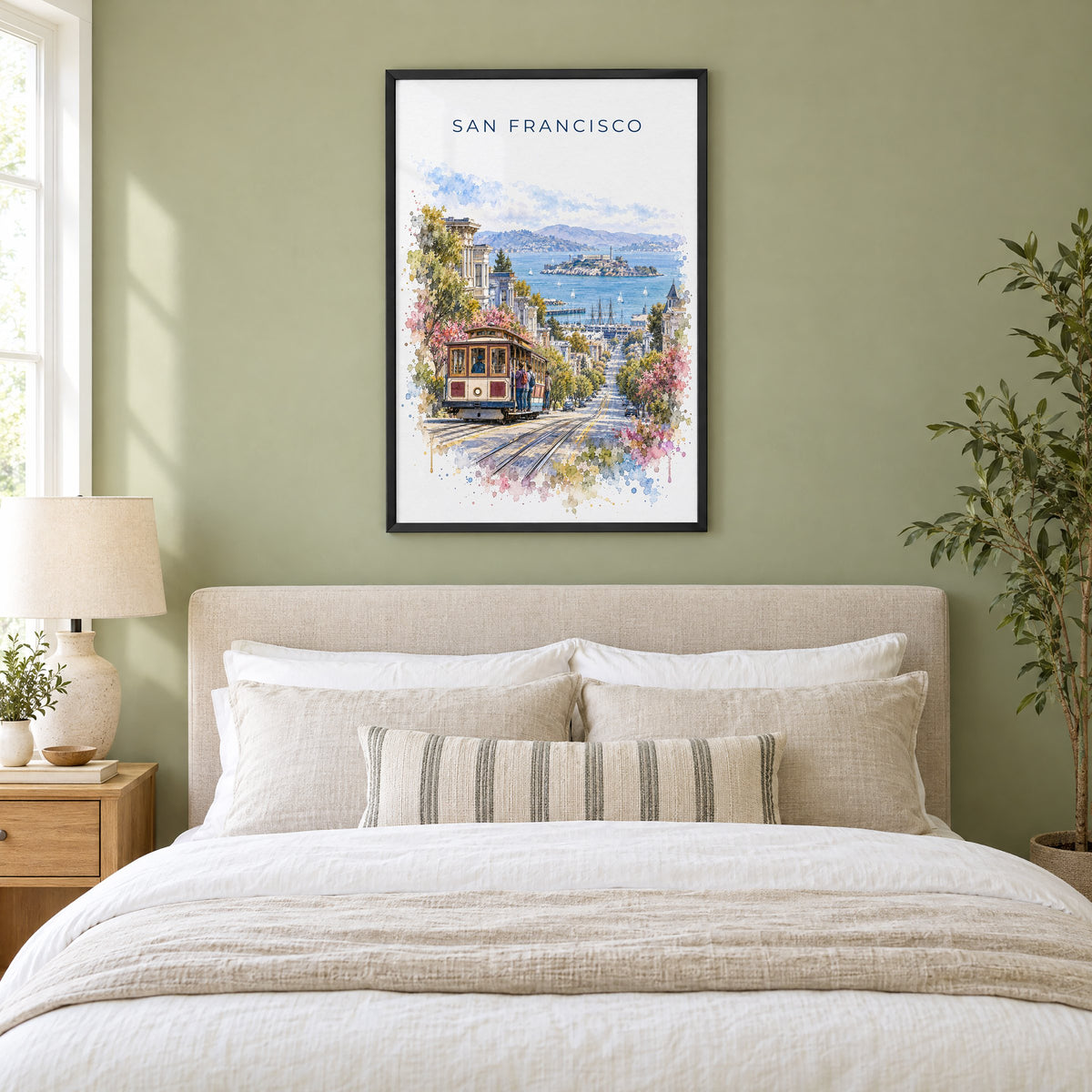 San Francisco Cable Car watercolor print in a black frame above an upholstered headboard in a sage green bedroom