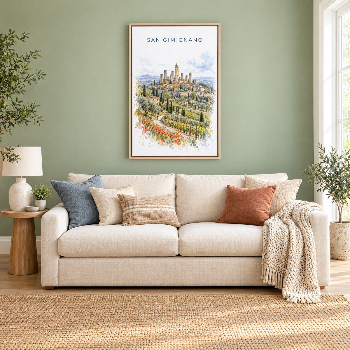 San Gimignano watercolor print as a natural floater canvas above a cream linen sofa on a sage green wall