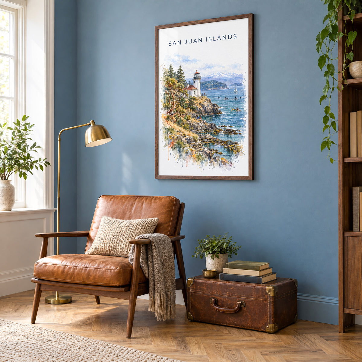 San Juan Islands watercolor print in a walnut frame on a blue wall above a leather armchair in a reading nook