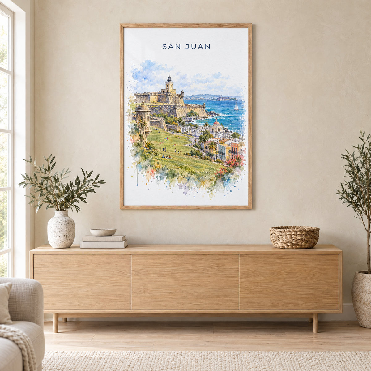 San Juan watercolor print in an oak frame above a light wood sideboard in a Scandinavian living room