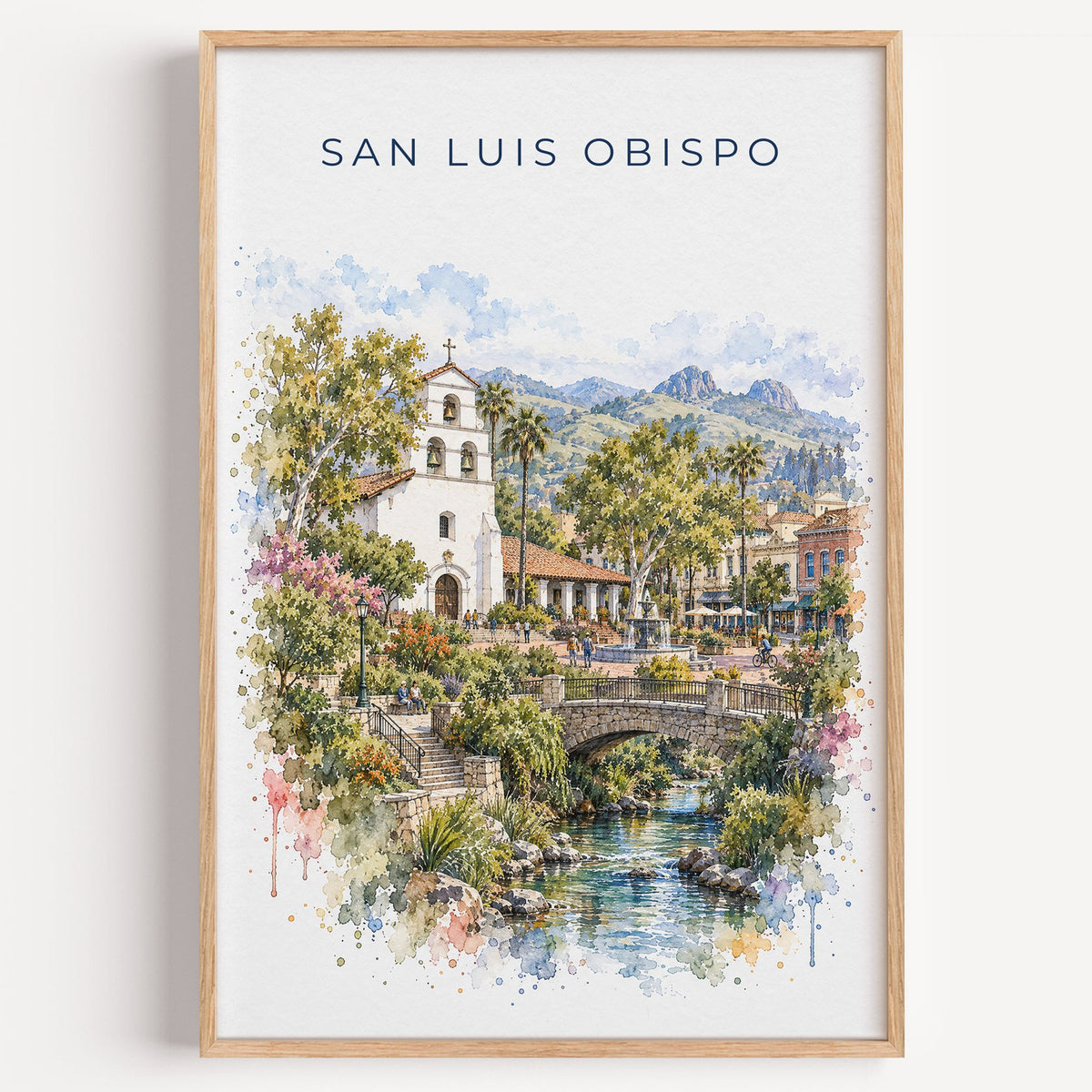 San Luis Obispo watercolor print in a light oak frame on a plain white wall