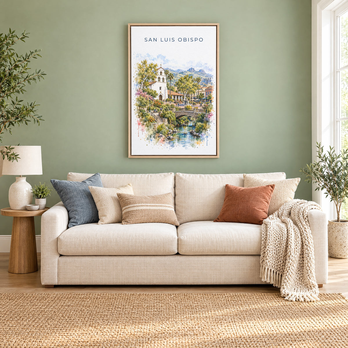 San Luis Obispo watercolor print as a natural floater canvas above a cream linen sofa on a sage green wall