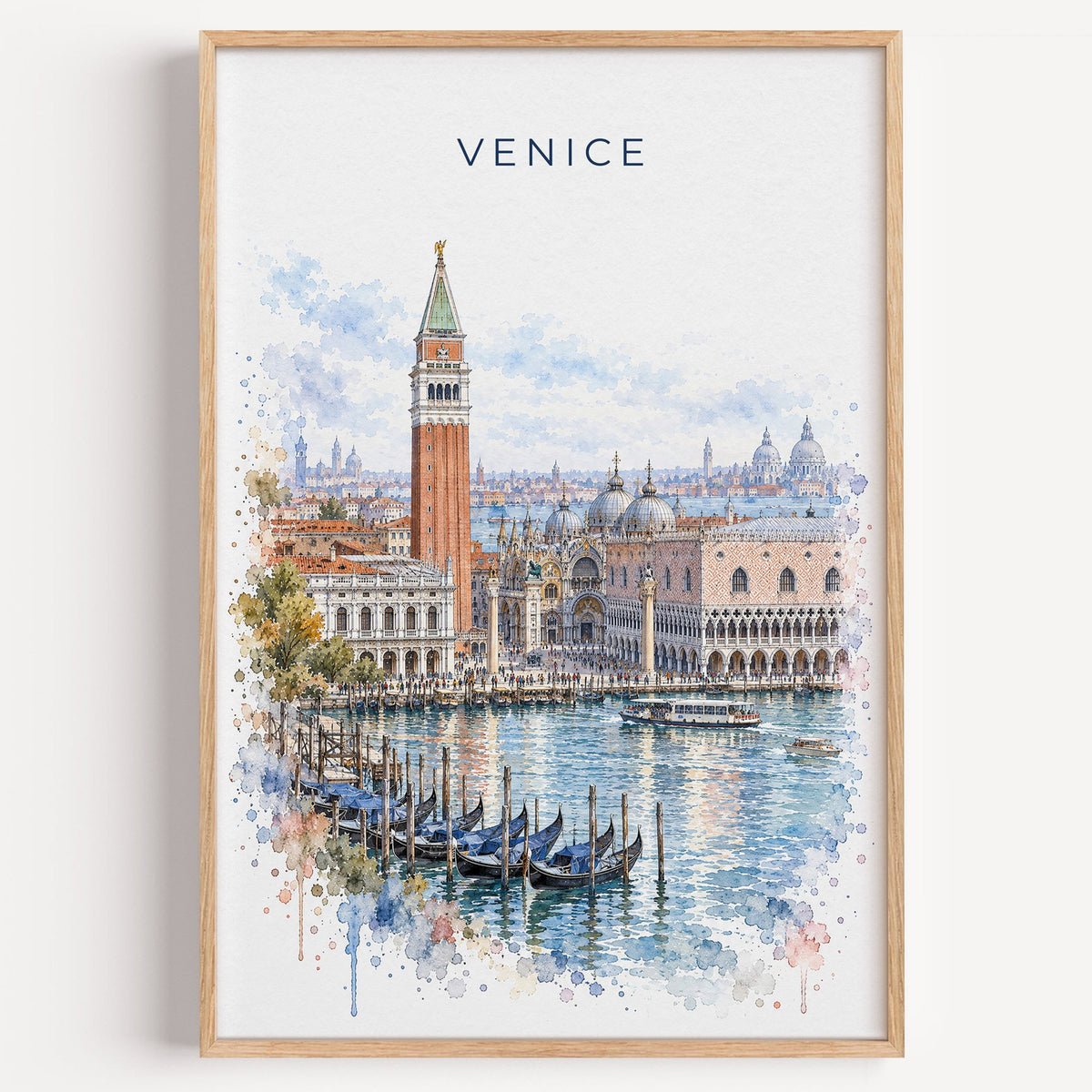 St. Mark's Square Venice watercolor print in a light oak frame on a plain white wall