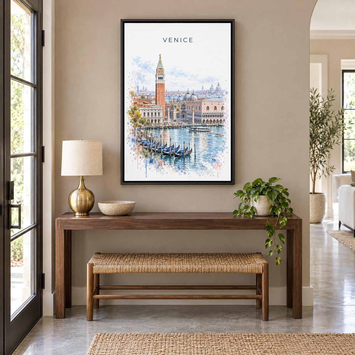 St. Mark's Square Venice watercolor print as a black floater canvas above a walnut console and woven bench in an entryway