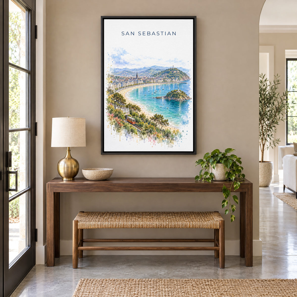 San Sebastian watercolor print as a black floater canvas above a walnut console and woven bench in an entryway