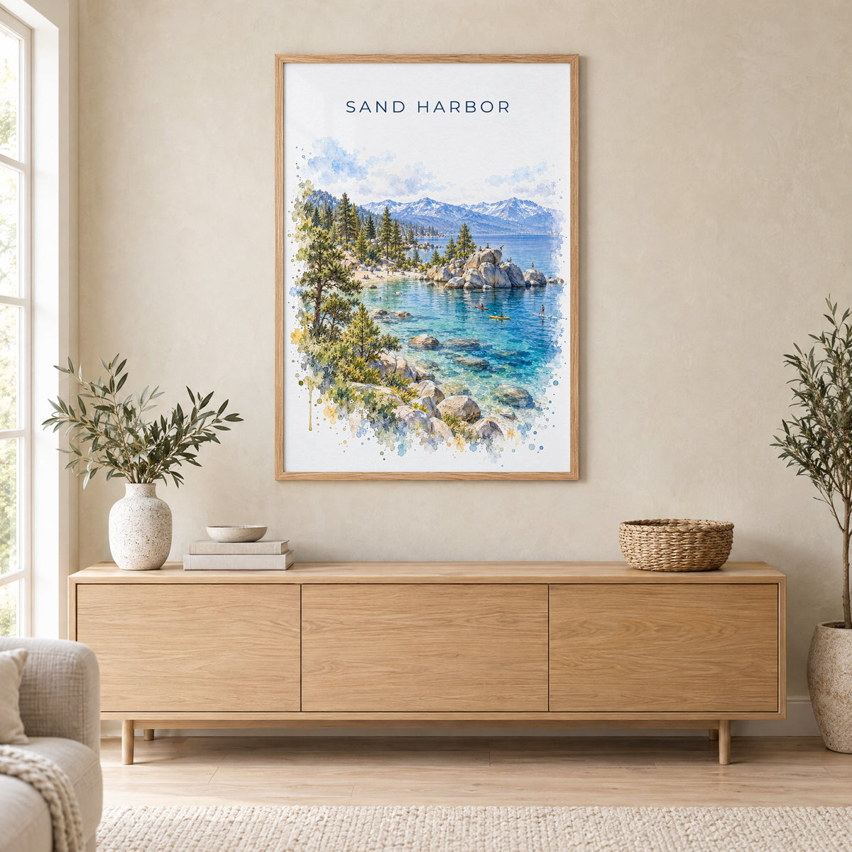 Sand Harbor watercolor print in an oak frame above a light wood sideboard in a Scandinavian living room