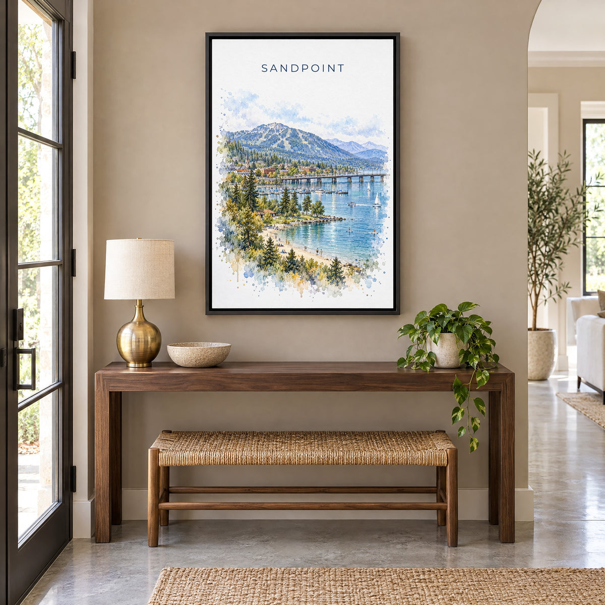 Sandpoint watercolor print as a black floater canvas above a walnut console and woven bench in an entryway