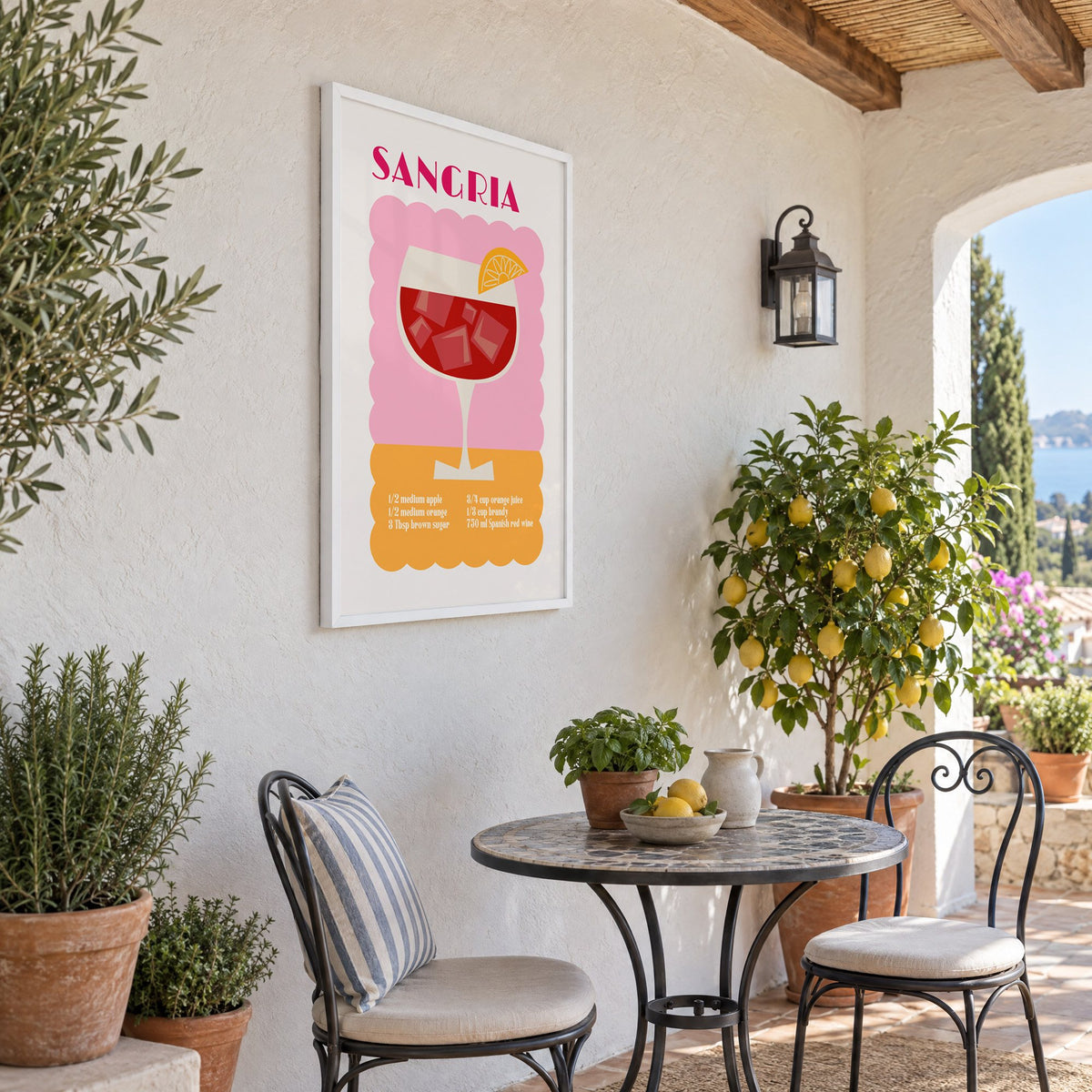 SANGRIA recipe pink and orange print in a white frame on a sunny patio wall beside a potted lemon tree