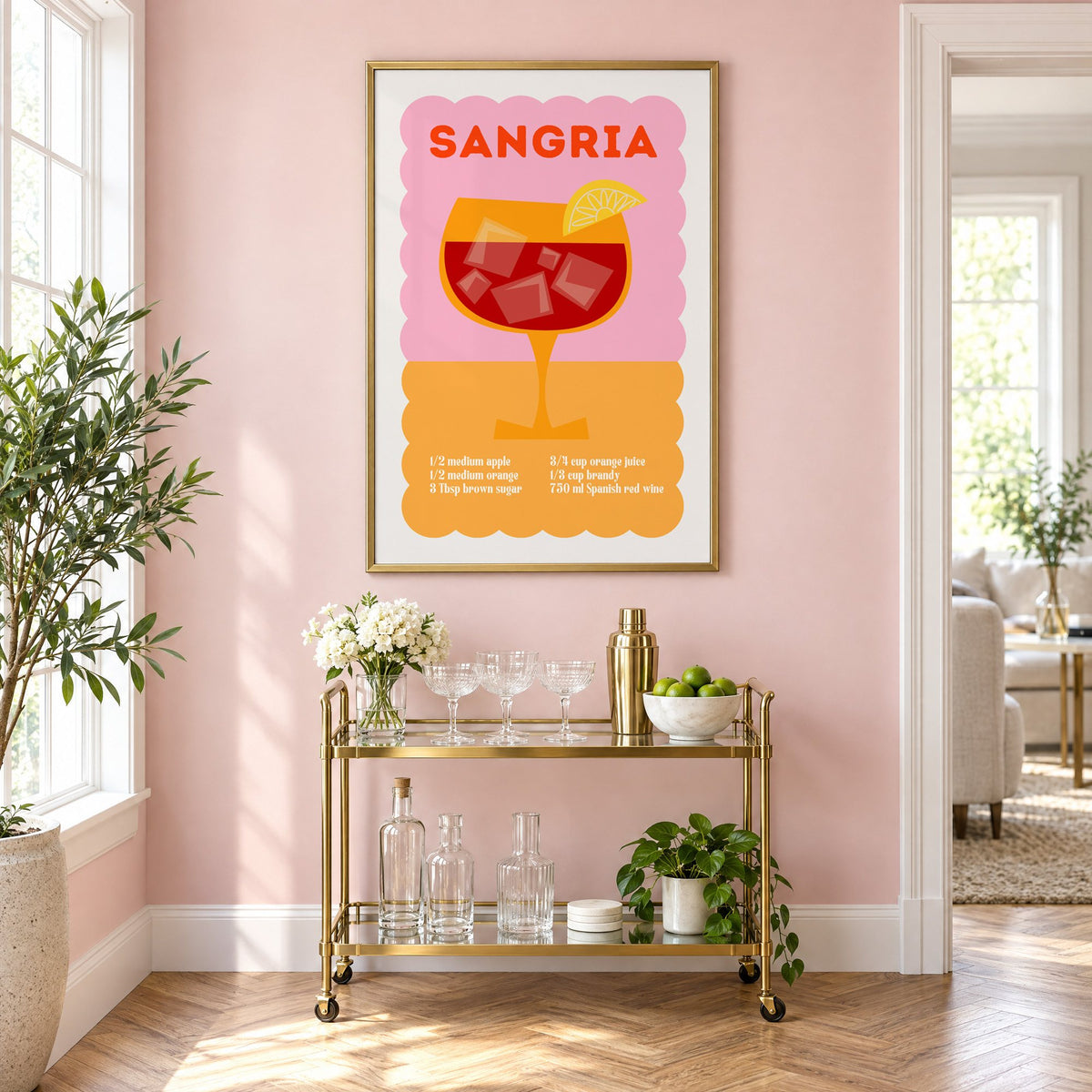 Sangria recipe pink and orange print in a brass frame above a gold bar cart on a blush pink wall