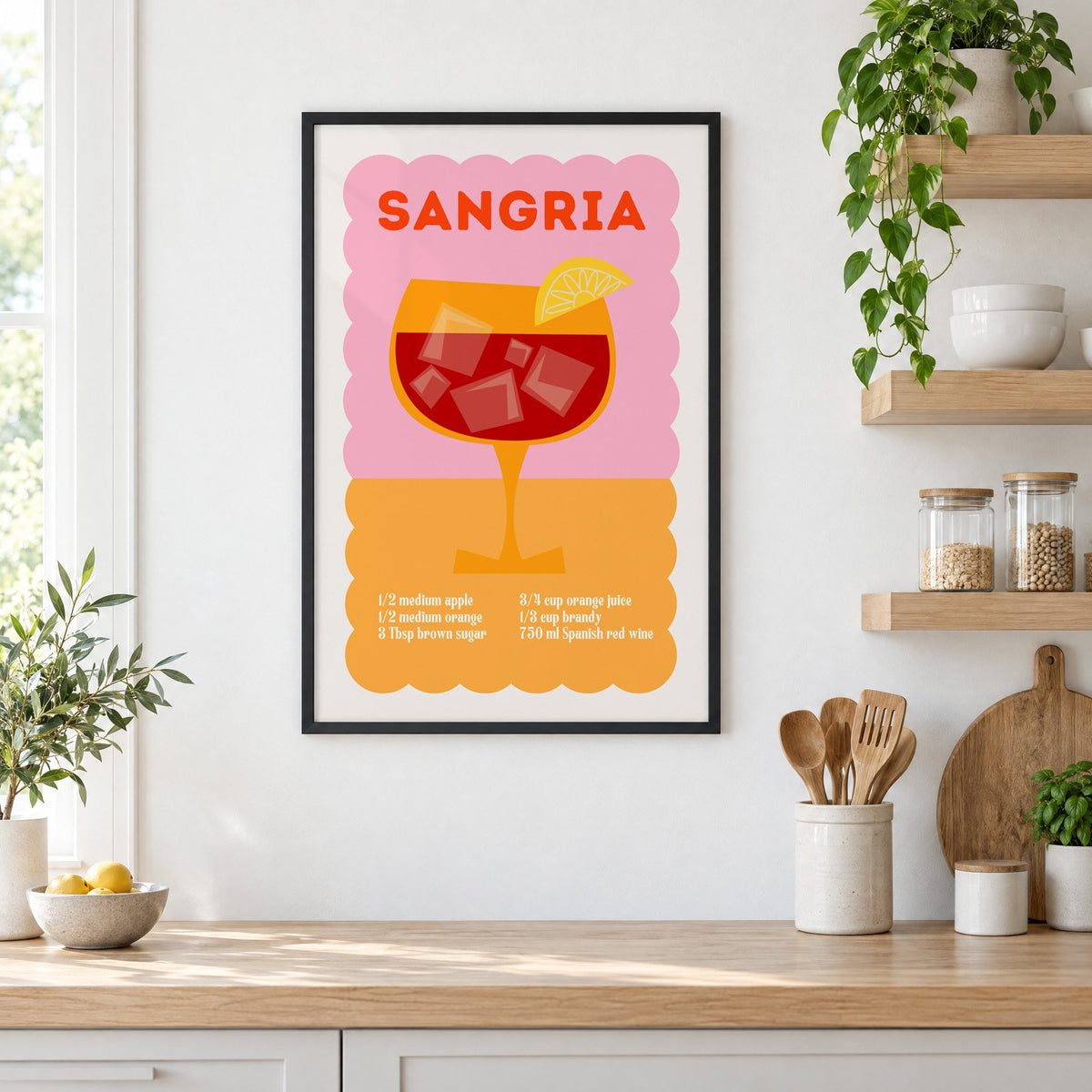 Sangria recipe pink and orange print in a black frame in a white kitchen beside open wood shelves and glass jars