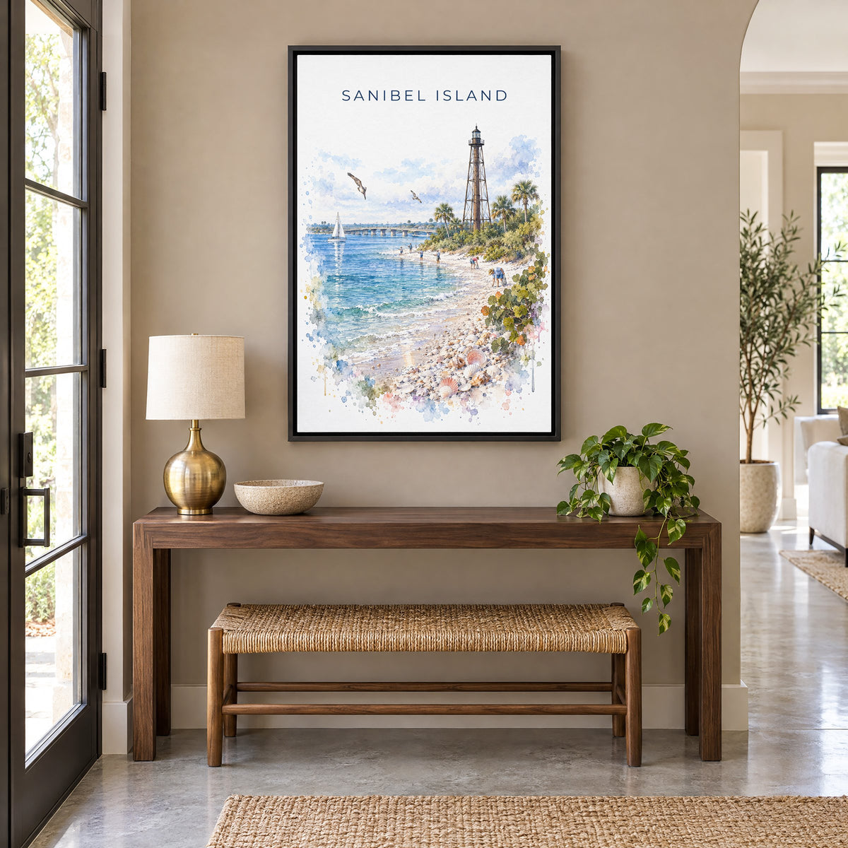 Sanibel Island watercolor print as a black floater canvas above a walnut console and woven bench in an entryway