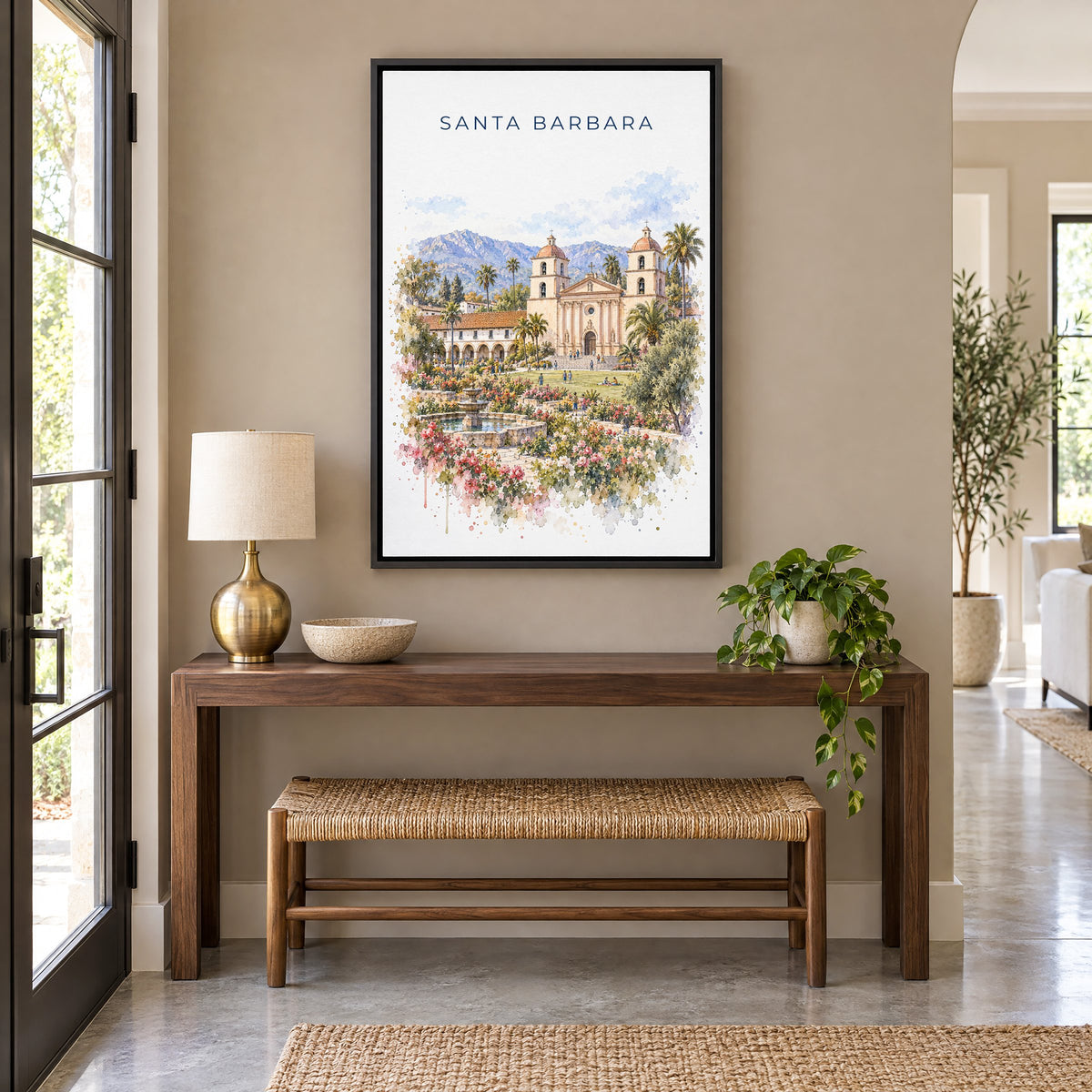 Santa Barbara watercolor print as a black floater canvas above a walnut console and woven bench in an entryway