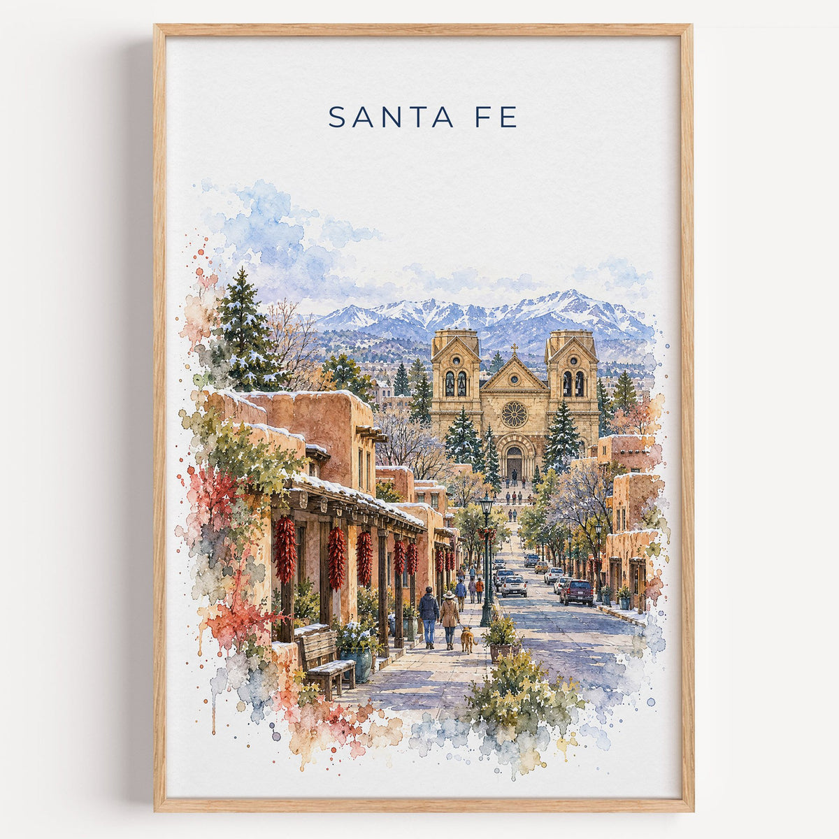 Santa Fe watercolor print in a light oak frame on a plain white wall