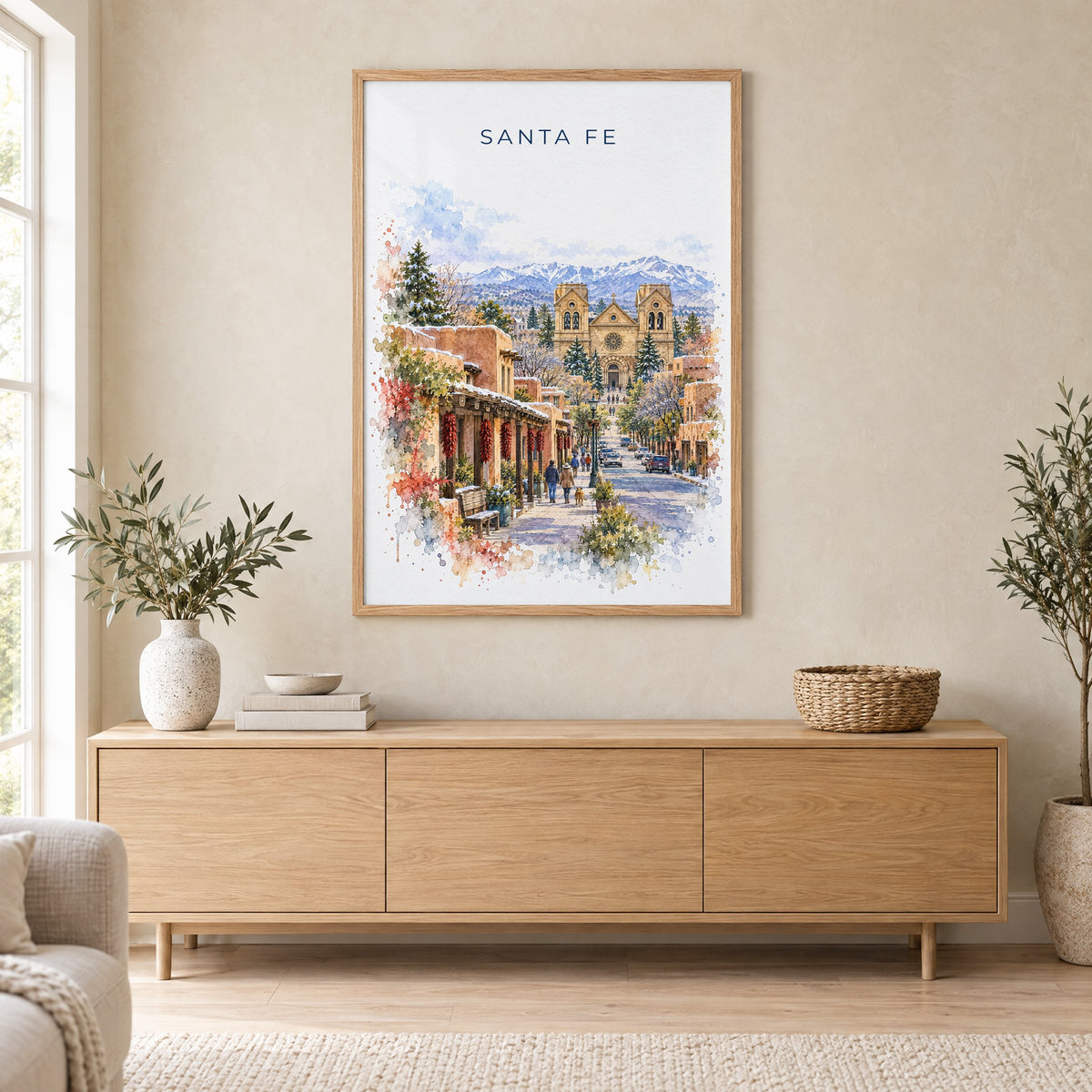 Santa Fe watercolor print in an oak frame above a light wood sideboard in a Scandinavian living room