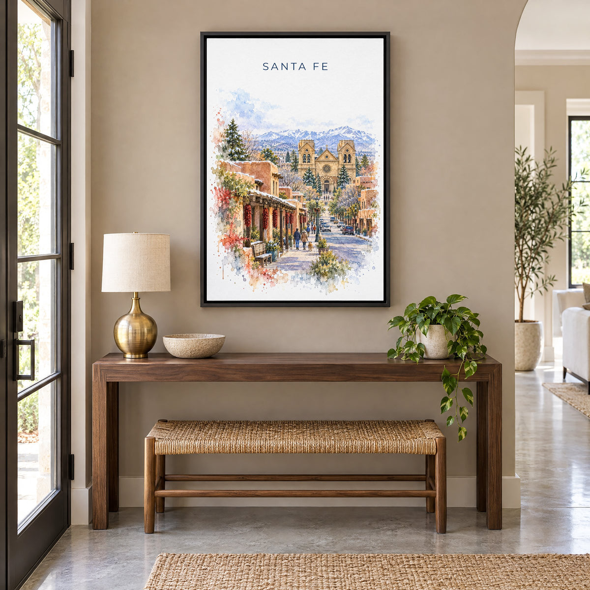Santa Fe watercolor print as a black floater canvas above a walnut console and woven bench in an entryway