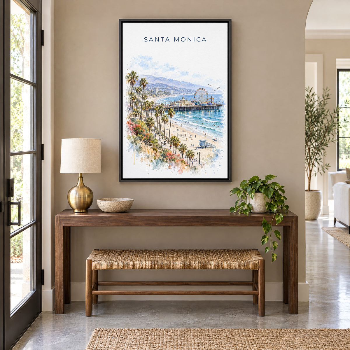 Santa Monica watercolor print as a black floater canvas above a walnut console and woven bench in an entryway