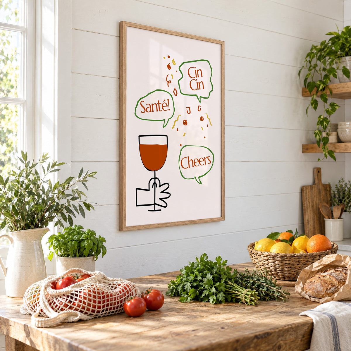 Cin Cin Santé Cheers speech bubbles wine print in an oak frame on a shiplap wall above a farm table with market tomatoes and citrus, seen at an angle