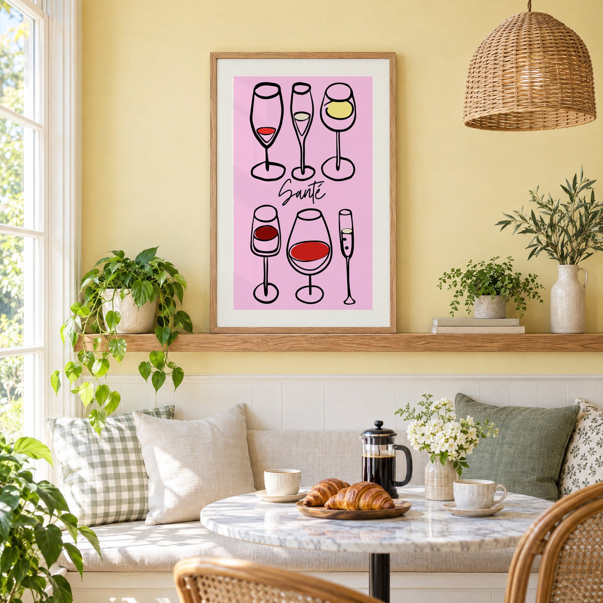 Santé wine glasses line art print in an oak frame on a picture ledge above a sunny breakfast nook
