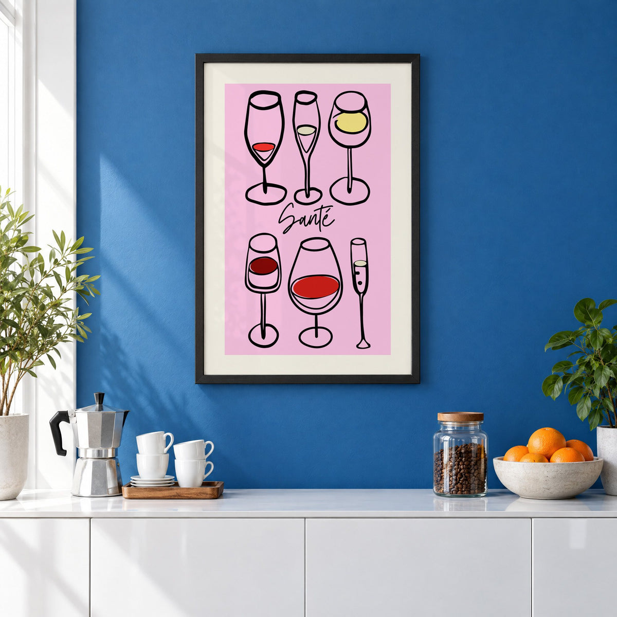 Santé wine glasses line art print in a black frame on a cobalt blue wall above a coffee station