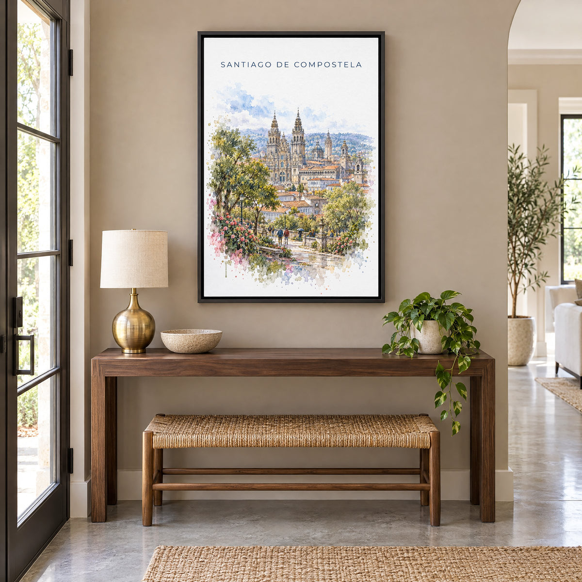Santiago de Compostela watercolor print as a black floater canvas above a walnut console and woven bench in an entryway