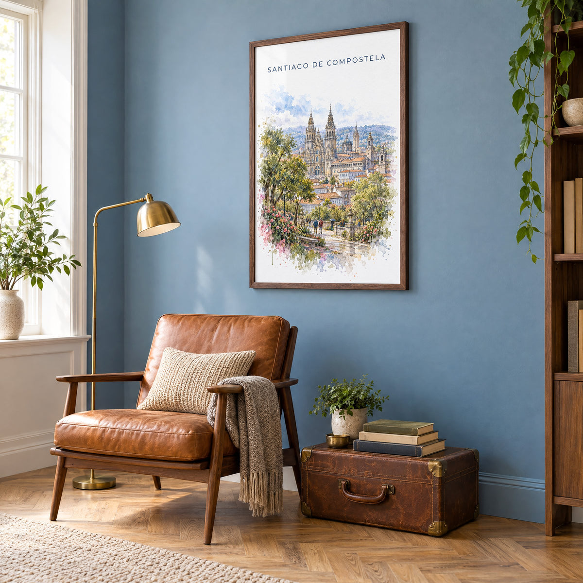 Santiago de Compostela watercolor print in a walnut frame on a blue wall above a leather armchair in a reading nook