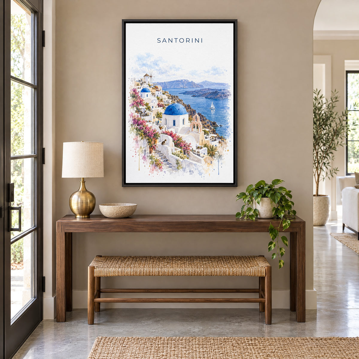 Santorini watercolor print as a black floater canvas above a walnut console and woven bench in an entryway