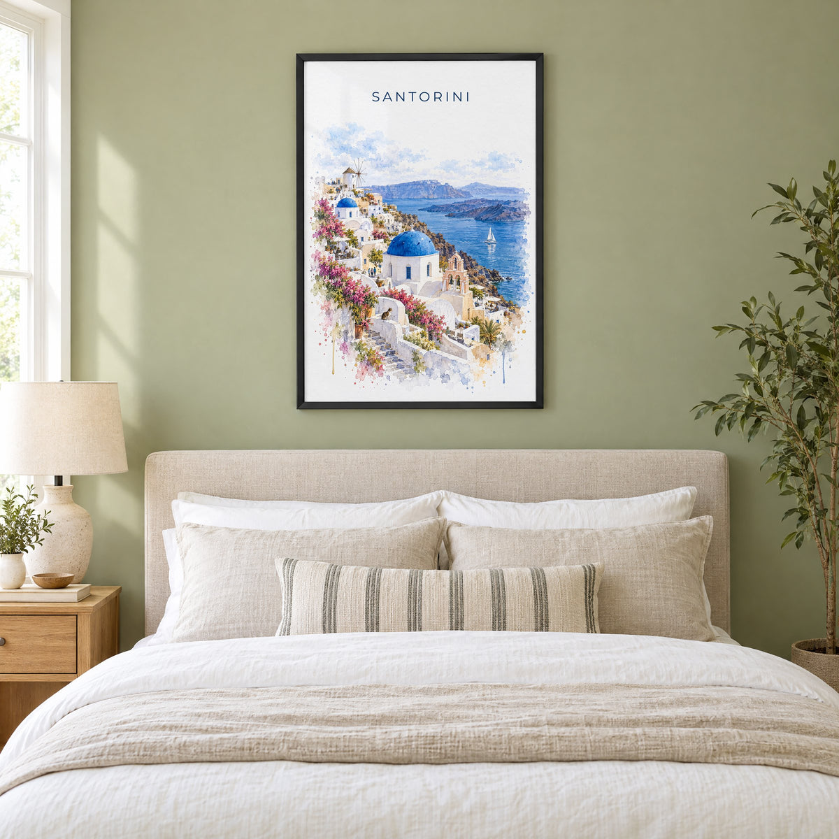 Santorini watercolor print in a black frame above an upholstered headboard in a sage green bedroom