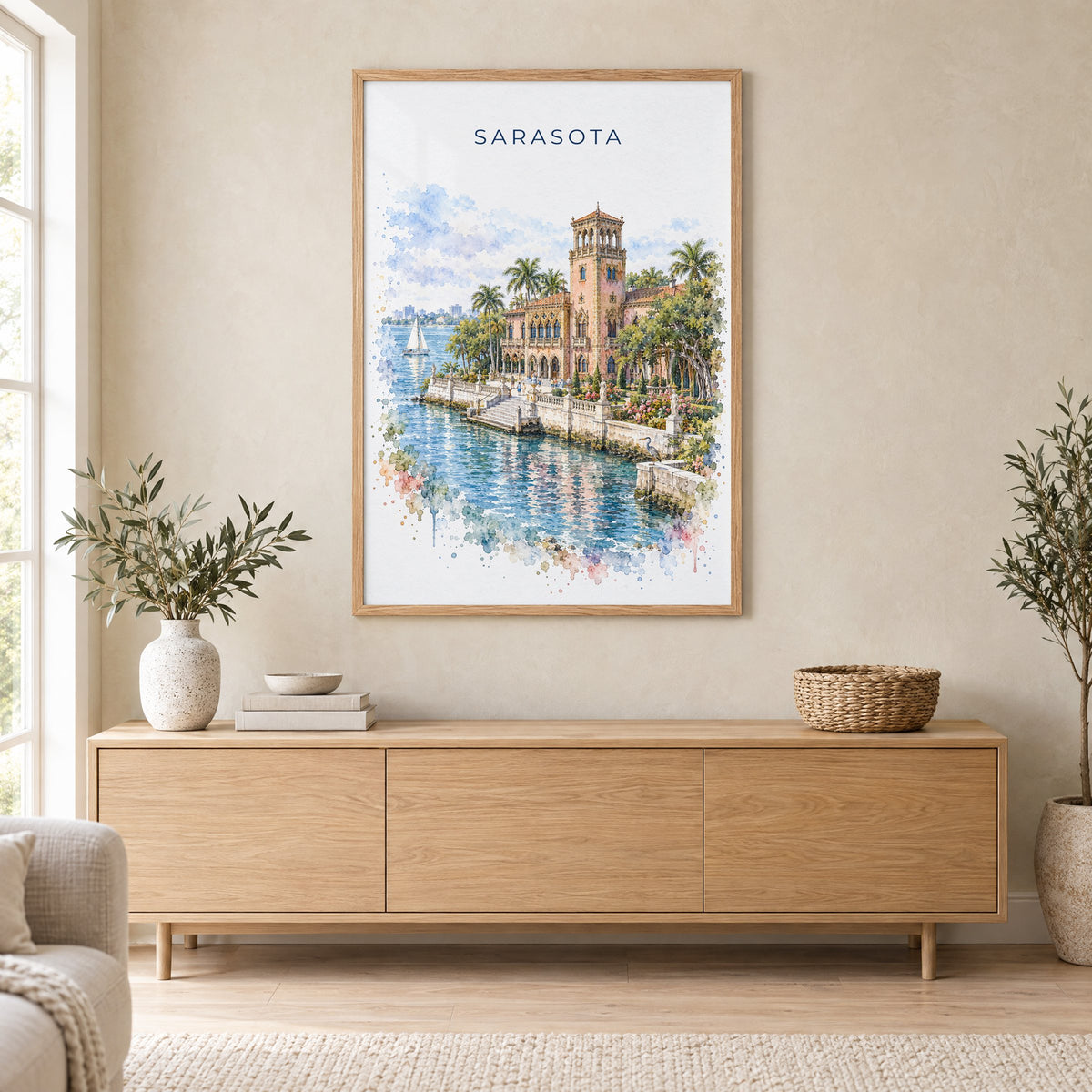 Sarasota watercolor print in an oak frame above a light wood sideboard in a Scandinavian living room