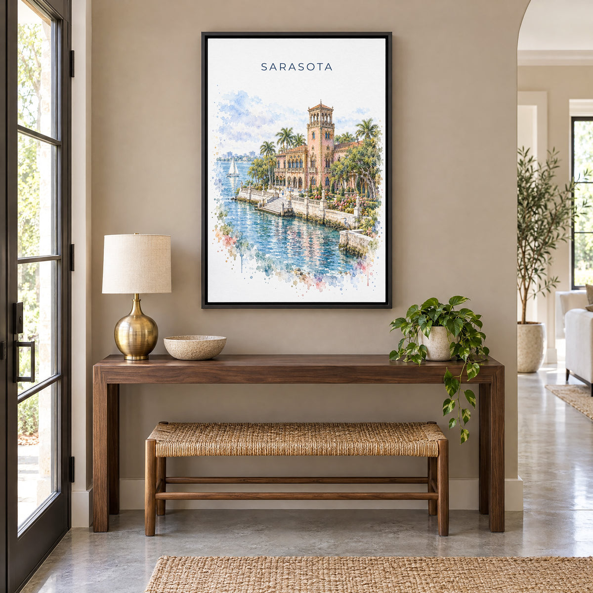 Sarasota watercolor print as a black floater canvas above a walnut console and woven bench in an entryway