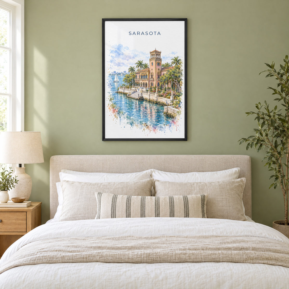 Sarasota watercolor print in a black frame above an upholstered headboard in a sage green bedroom