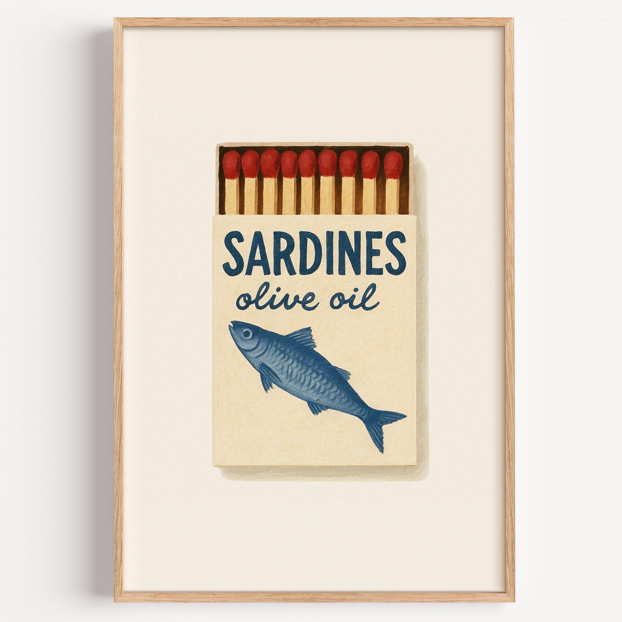 Sardines olive oil matchbox print in a light oak frame on a plain white wall
