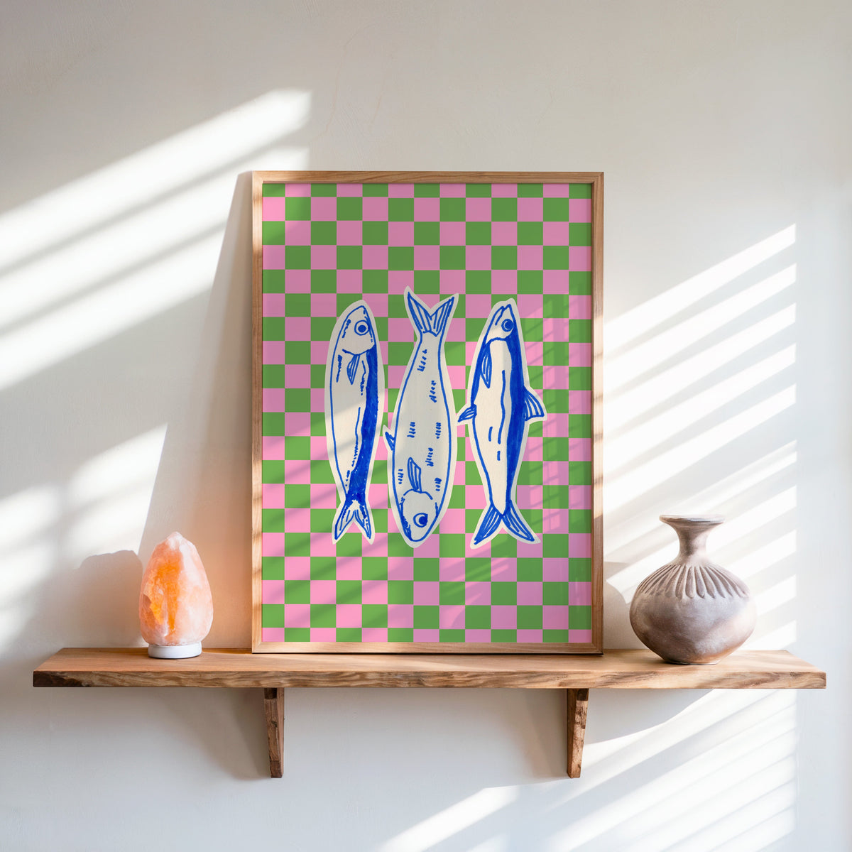 Sardines checkerboard print in an oak frame on a live-edge shelf beside a salt lamp