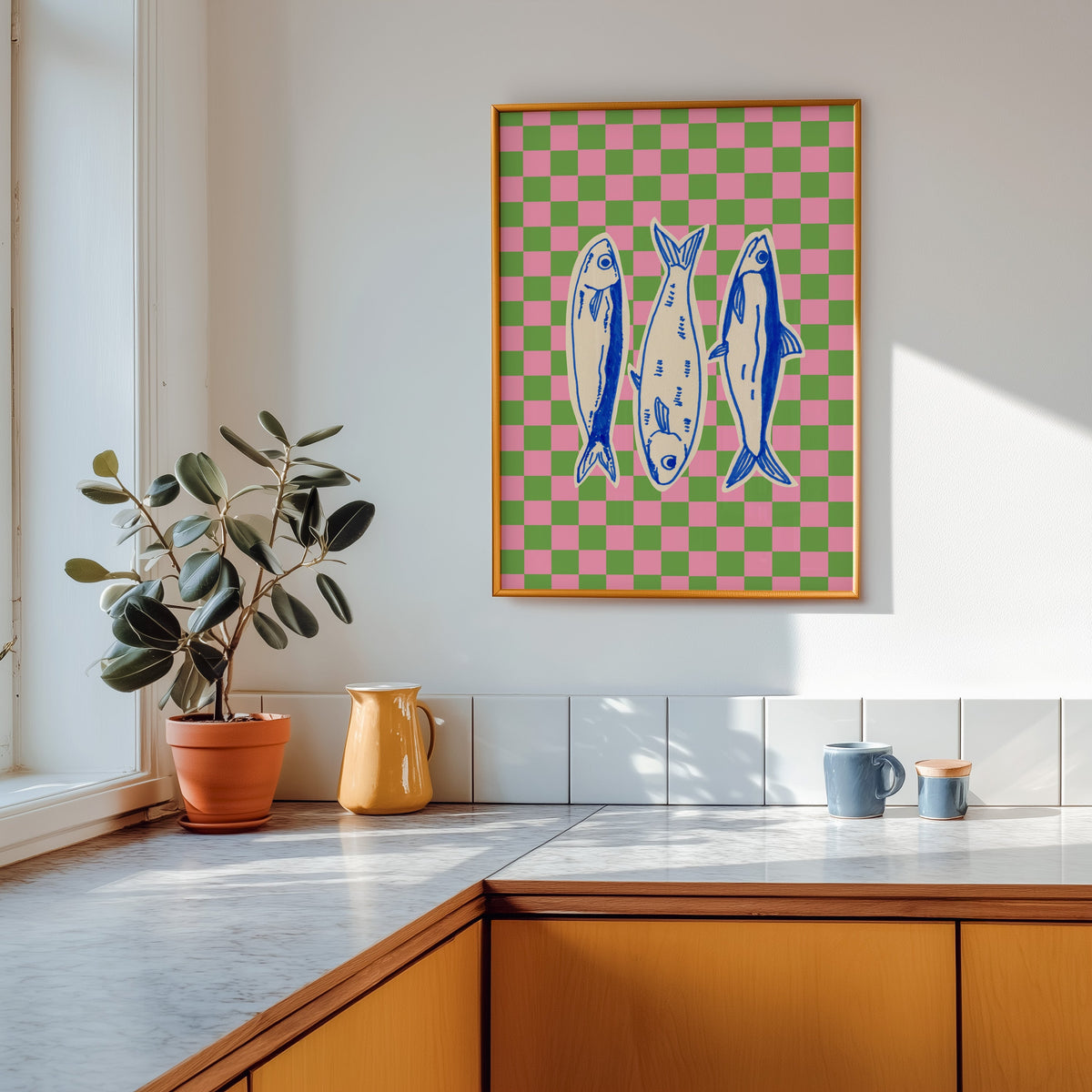 Sardines checkerboard print shown in a gold frame above a marble counter in a tan kitchen